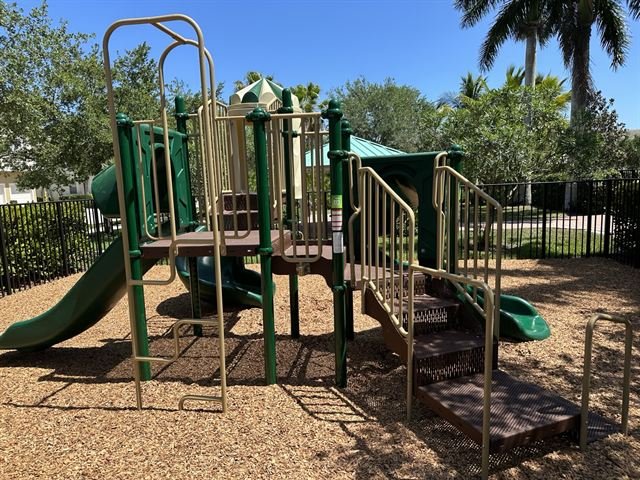 Community playground structure with multiple slides and climbing panels.