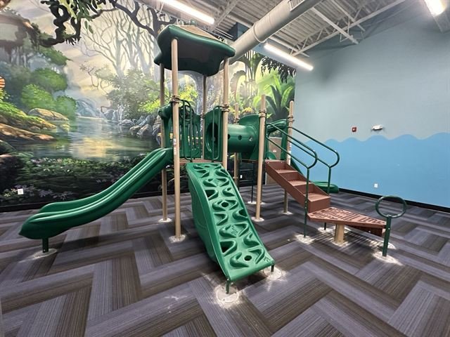 Indoor commercial playground installation with themed wall mural.